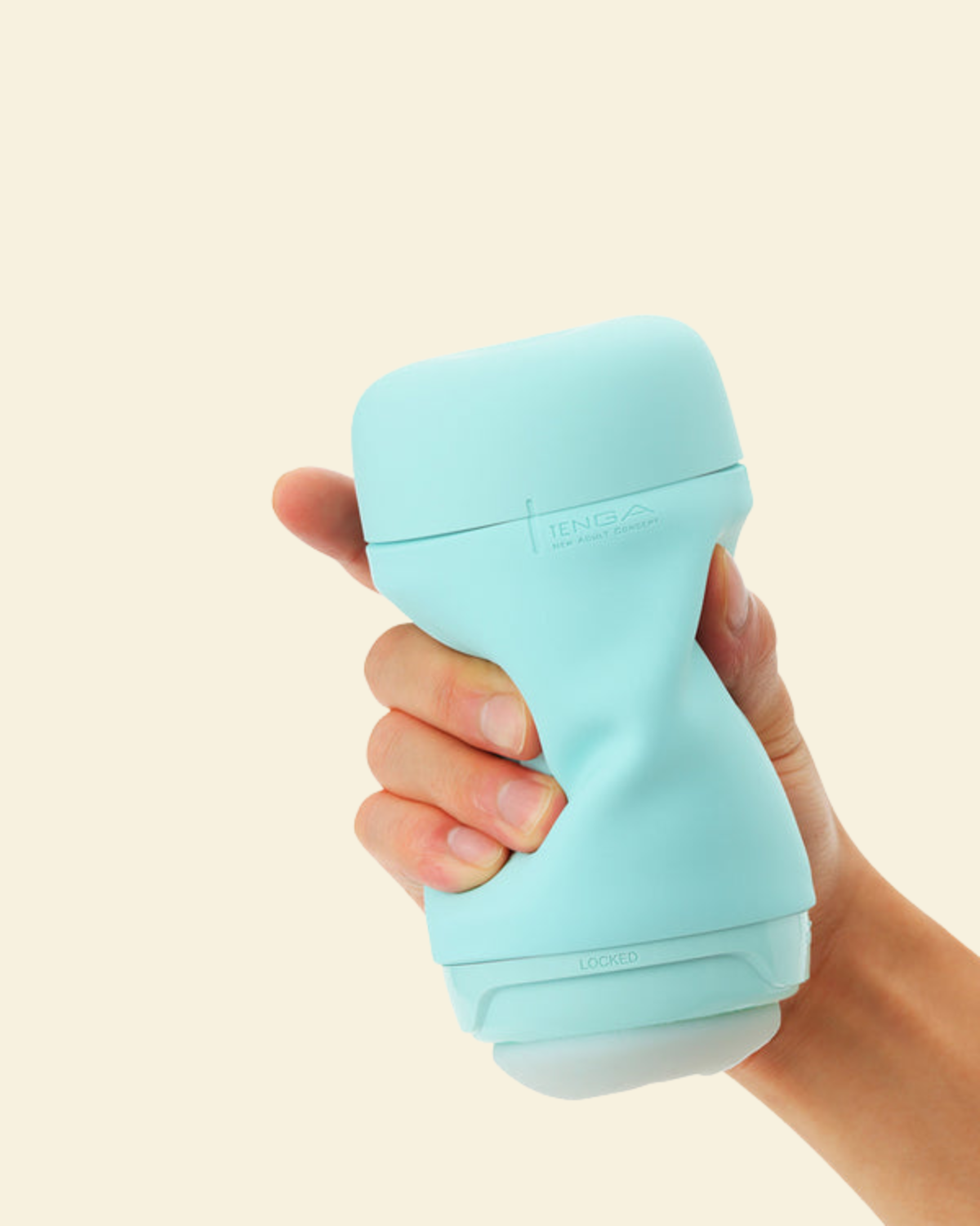 A hand holding a mint green reusable stroker 
