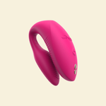 Pink silicone vibrator on beige background