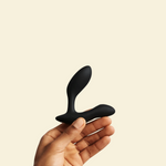 Hand holding black vibrating butt plug 